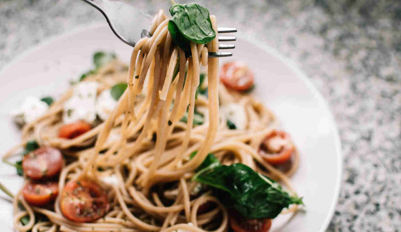 Gli spaghetti con la feta, i pomodorini e gli spinaci