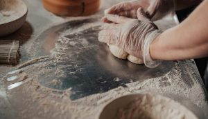 Persona lavora la farina e impasta - foto pexels - streetfoodnews.it